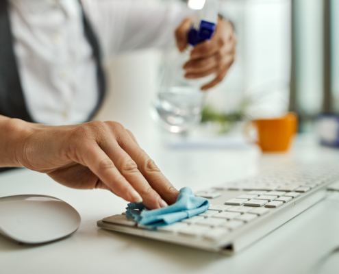 Close Up Of Businesswoman Cleaning Computer Keyboard
